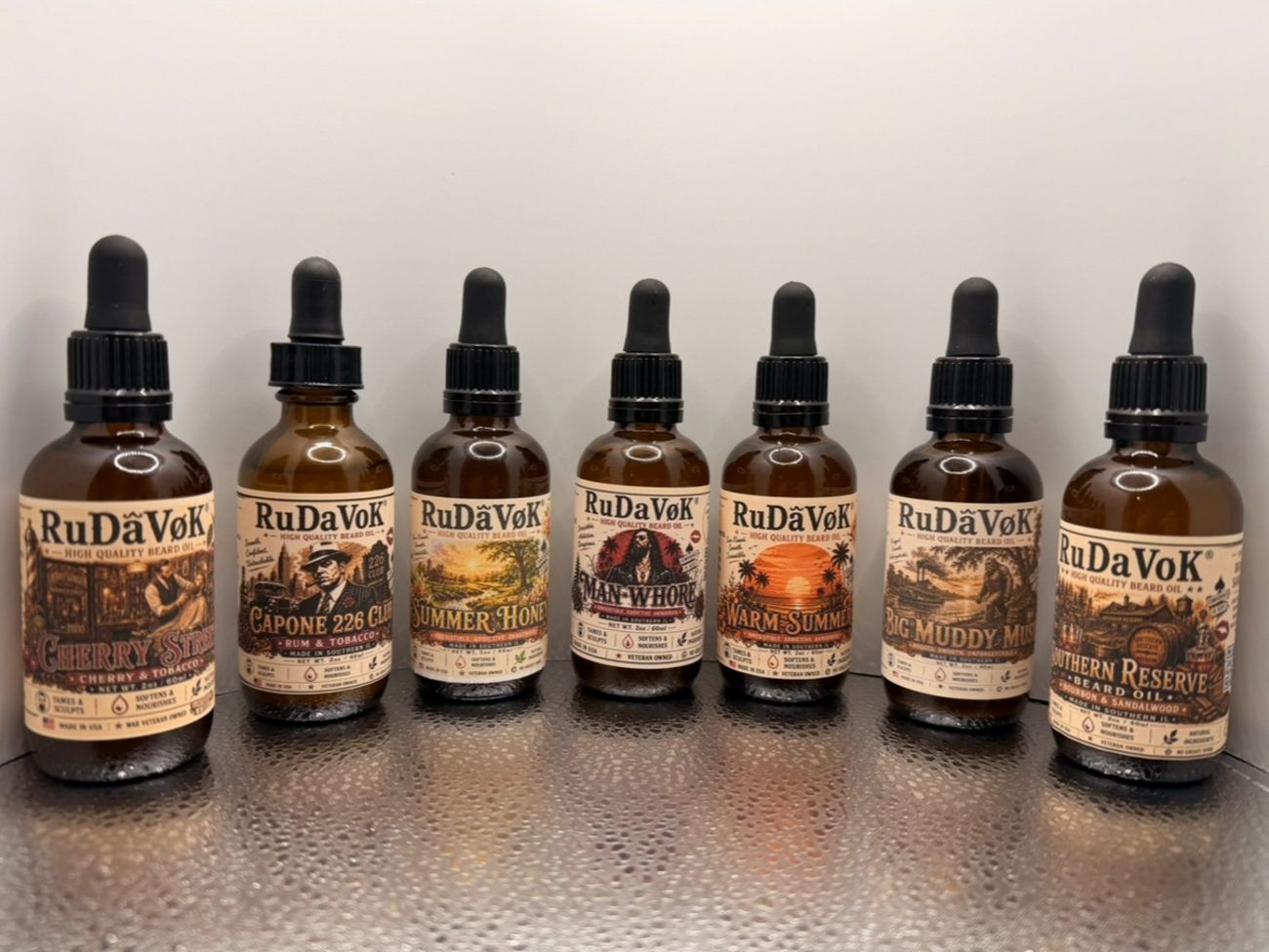 Real photo of seven RuDaVoK beard oil bottles in a row on the workbench